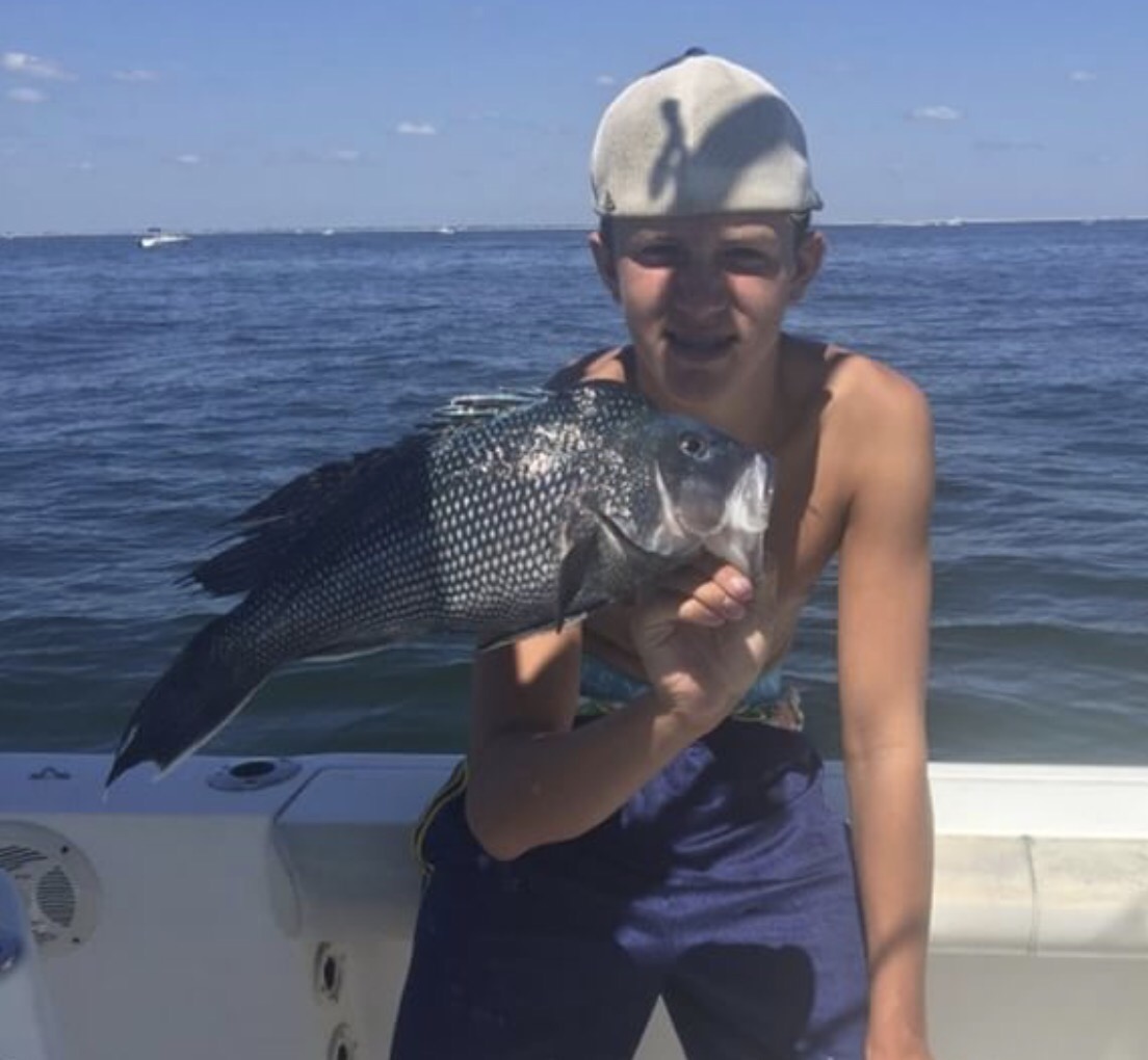 A man holding a fish on the boat