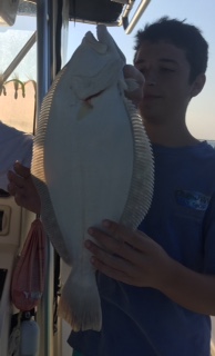 A boy holding a fish in his hands.