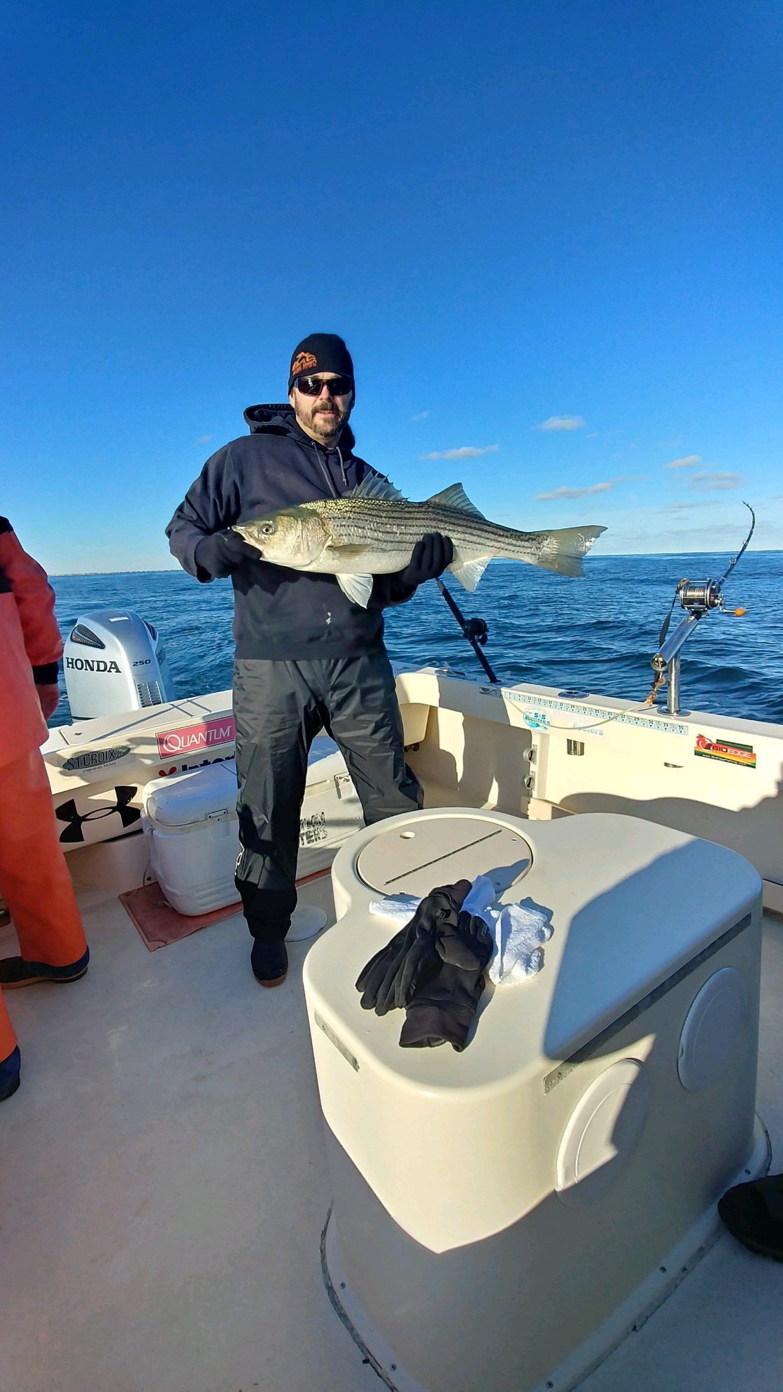 A man holding a large fish on the boat.