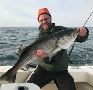 A man holding a fish on top of a boat.