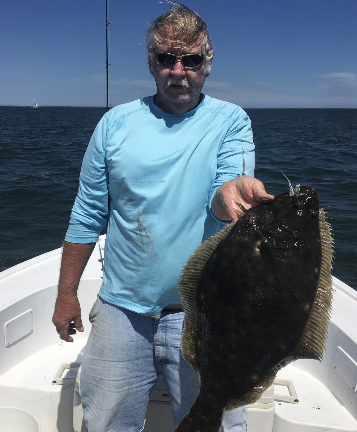 A man holding a fish on the boat