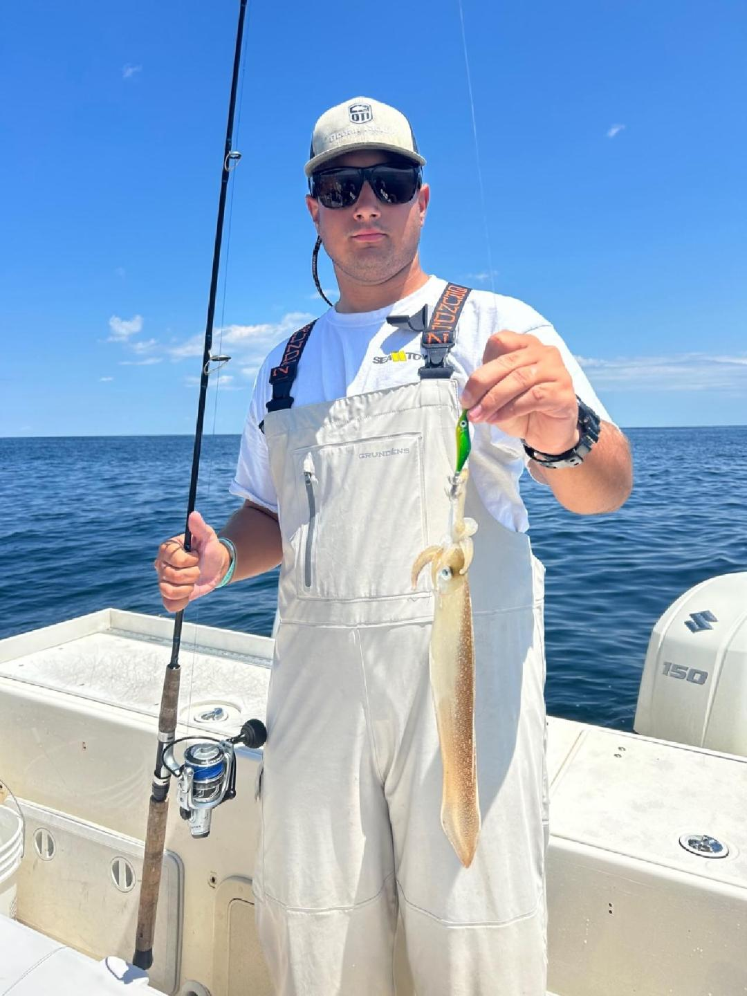 A man holding a fish on top of a boat.